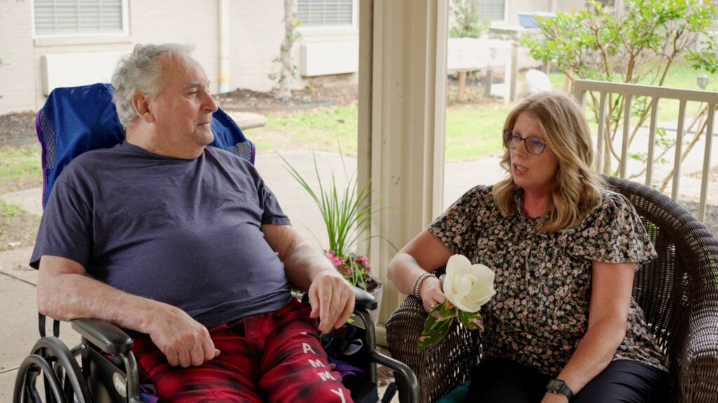A man in a wheel chair sits with a woman during a respite care visit